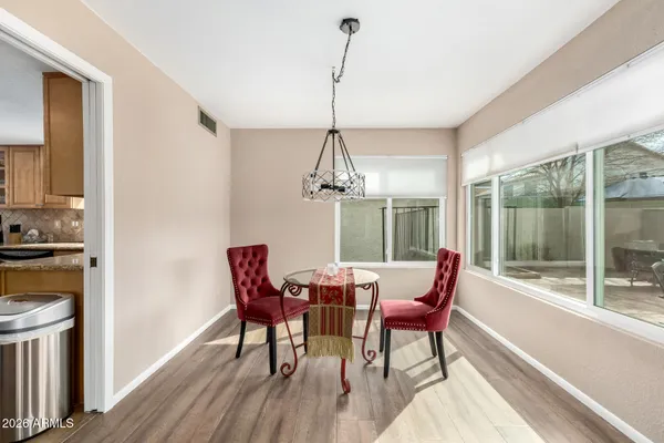 a dining room with furniture a chandelier and wooden floor