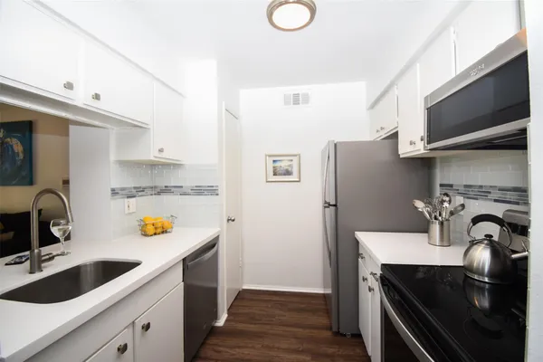 a kitchen with stainless steel appliances a sink stove and refrigerator