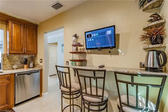 a kitchen with stainless steel appliances granite countertop a stove top oven a sink a dining table and chairs with wooden floor