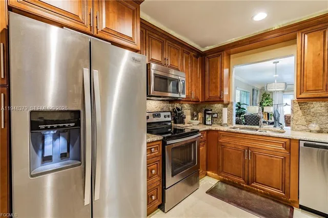 a kitchen with stainless steel appliances granite countertop a refrigerator and a stove