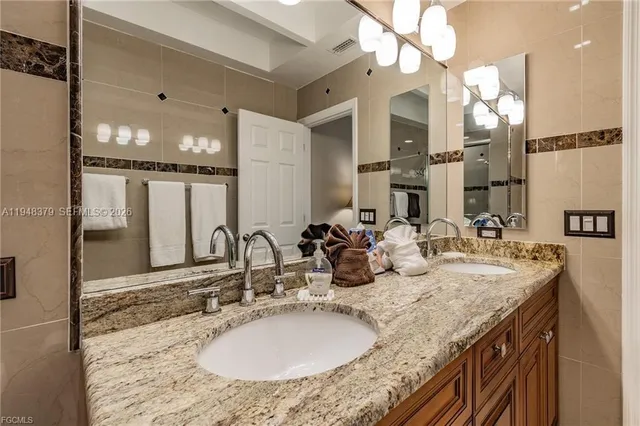 a bathroom with a granite countertop sink a large mirror and a shower