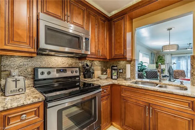 a kitchen with stainless steel appliances granite countertop a sink stove and microwave