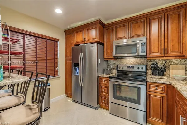 a kitchen with stainless steel appliances granite countertop a refrigerator stove and microwave