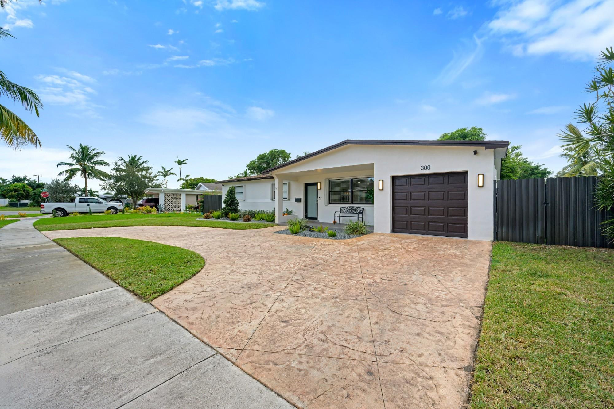 300 Southwest 65th Way Pembroke Pines, FL 33023 - Photo 2 of 35 a front view of a house with a yard and garage