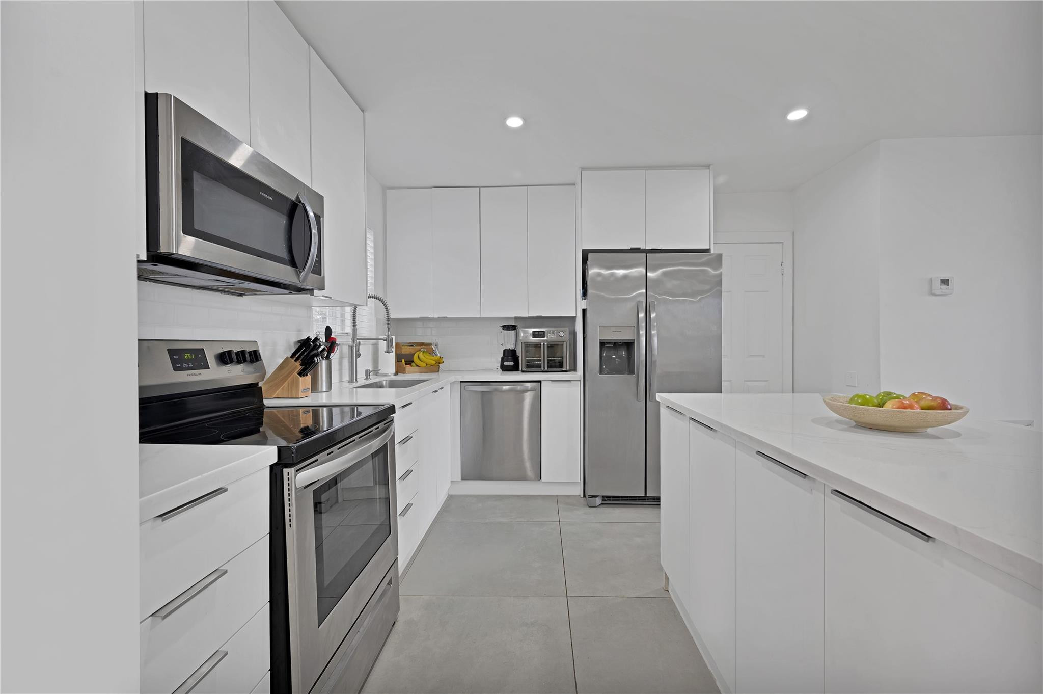 300 Southwest 65th Way Pembroke Pines, FL 33023 - Photo 5 of 35 a kitchen with a sink a stove and refrigerator