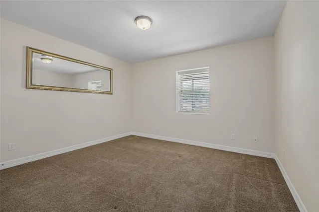 an empty room with a window and a ceiling fan