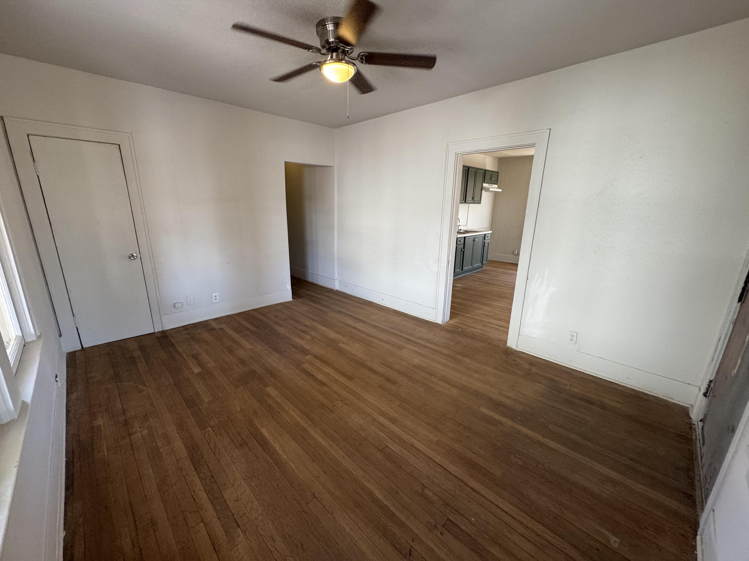 1903 16th Street, Unit A Lubbock, TX 79401 - Photo 3 of 7 wooden floor in an empty room with a window