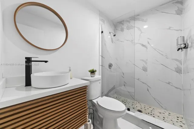 a bathroom with a sink toilet and a mirror