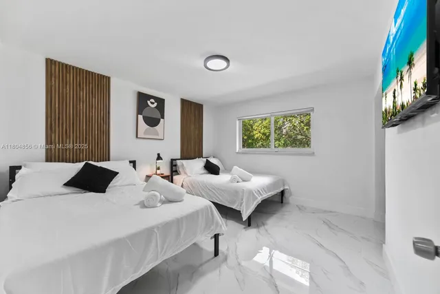 a bedroom with 2 bed and a window