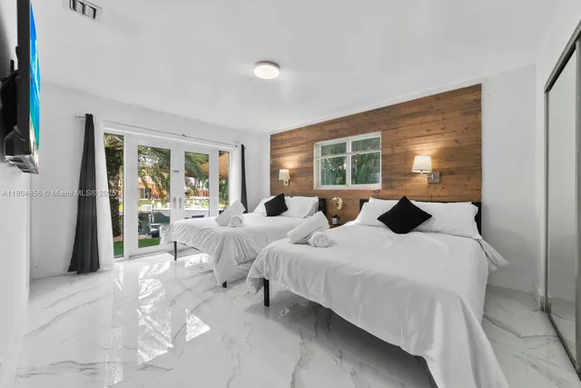 a bedroom with bed and large windows