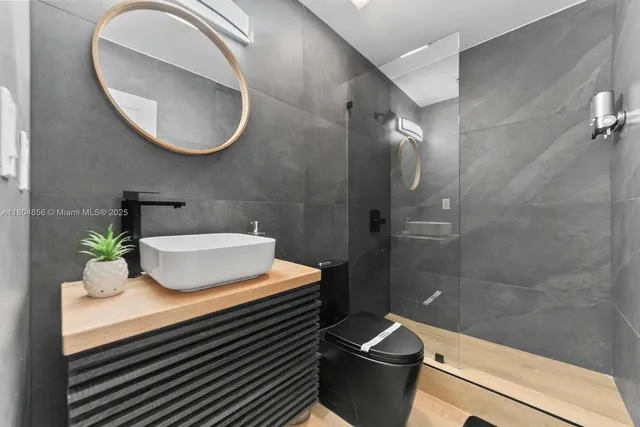 a bathroom with a sink a toilet and shower