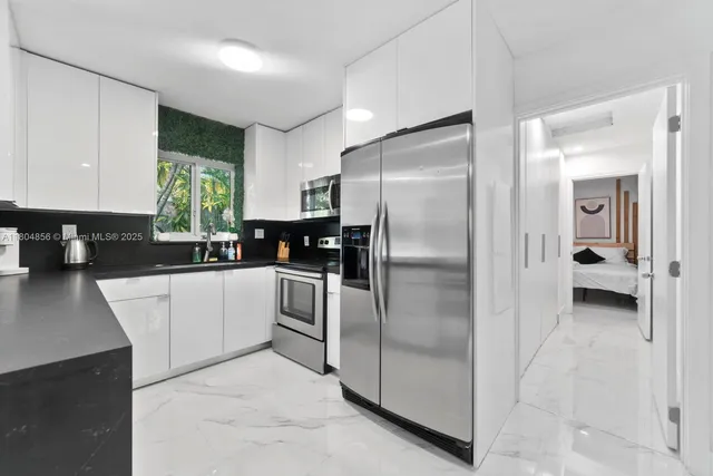 a kitchen with a refrigerator and a stove top oven