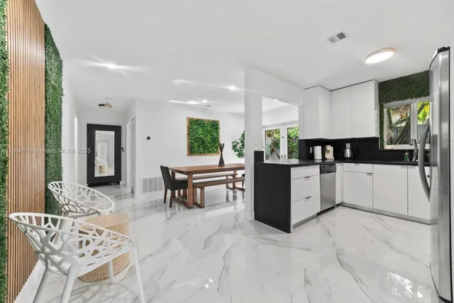 a kitchen with stainless steel appliances kitchen island granite countertop a sink and counter space
