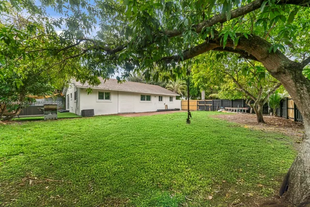 a view of a house with backyard and a tree