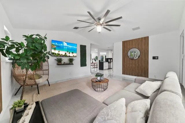 a living room with furniture a chandelier and a flat screen tv