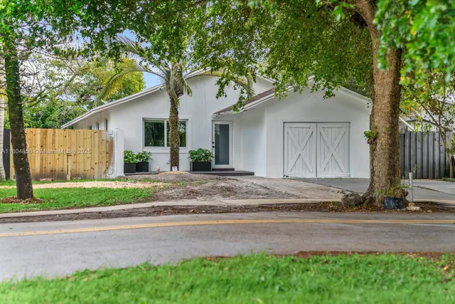 a white house that has a tree in front of it