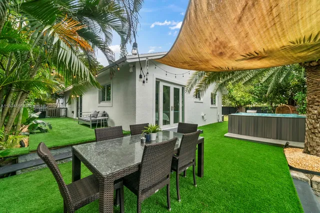 a view of a chair and table in backyard of the house