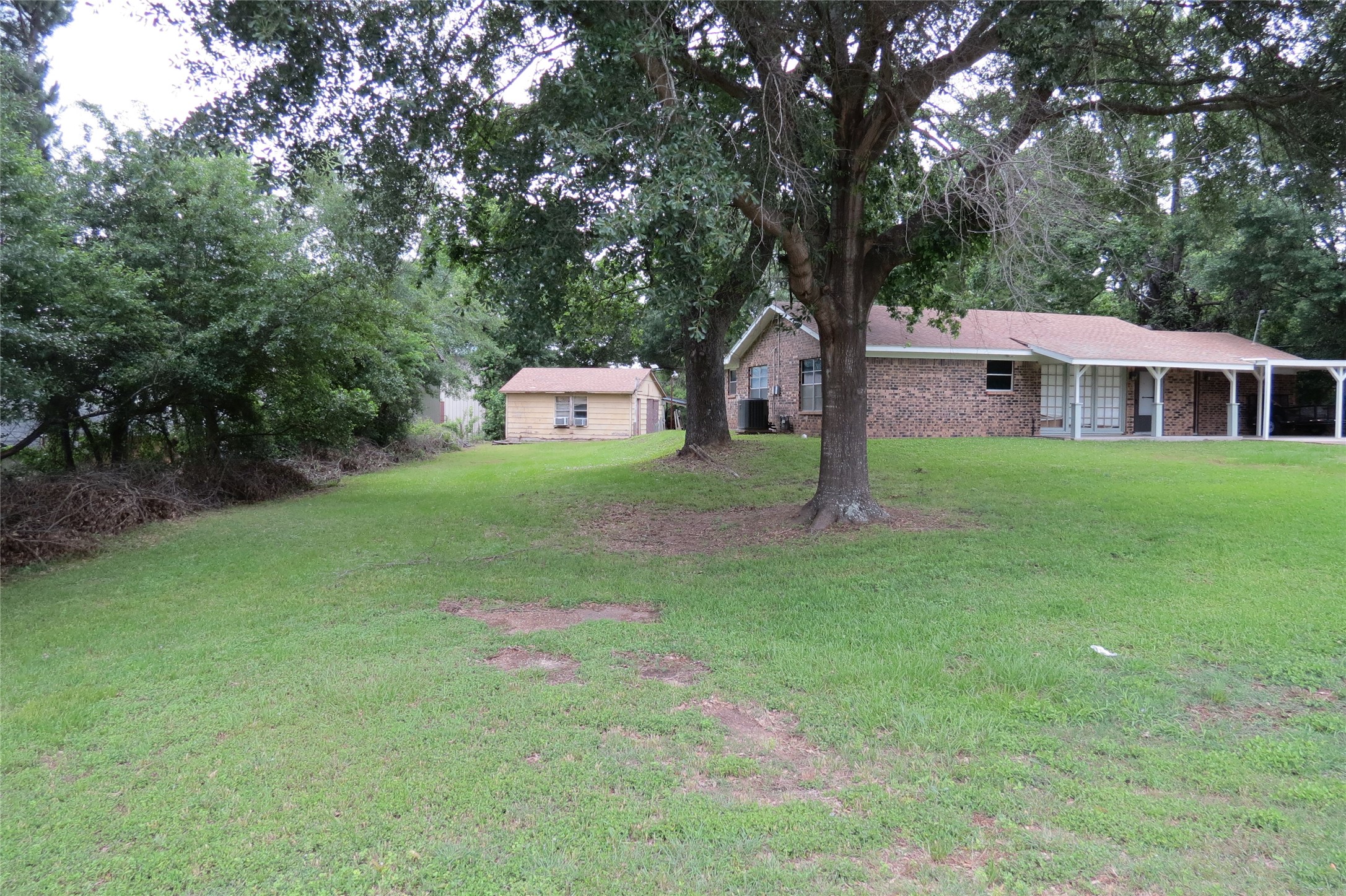 3120 Montgomery Road Huntsville, TX 77340 - Photo 4 of 16 a backyard of a house with table and chairs plants and large tree