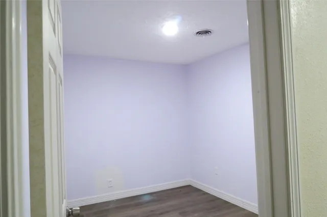 an empty room with wooden floor and closet