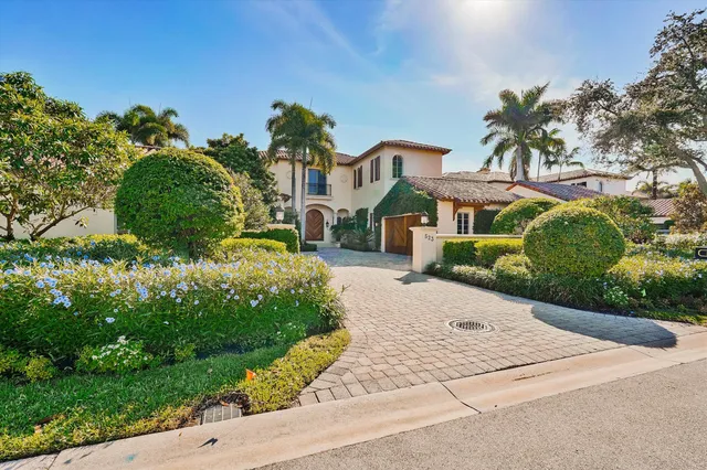 a front view of a house with a yard and potted plants