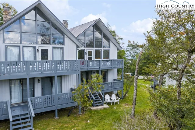 a view of a house with wooden deck and furniture