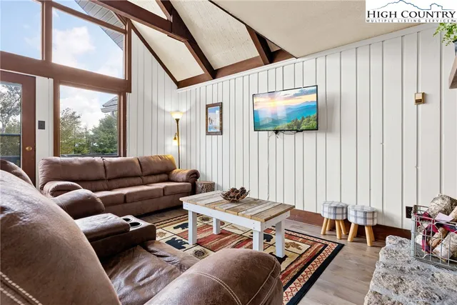 a living room with furniture a flat screen tv and a window