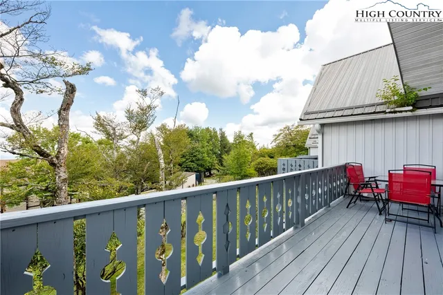 a balcony with wooden floor and outdoor seating