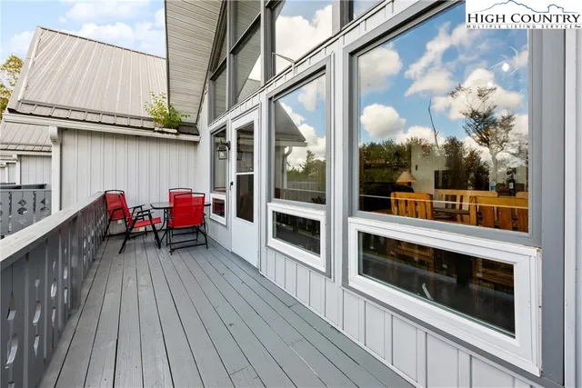 a view of a balcony with two chairs and wooden floor