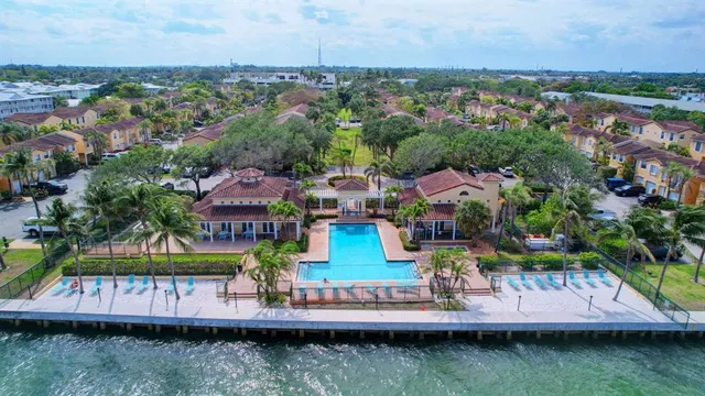 an aerial view of residential houses with outdoor space and lake view