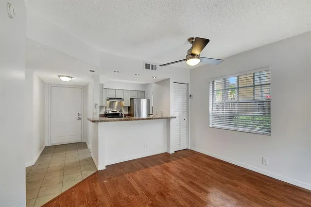 a kitchen with kitchen island a refrigerator wooden floor and a fireplace
