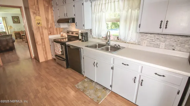 a kitchen with metallic refrigerator and sink