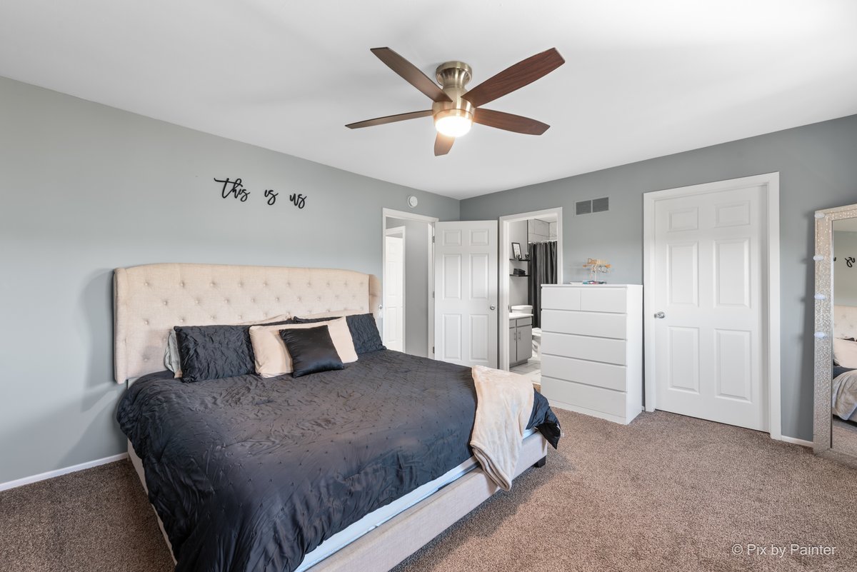 1104 Florimond Drive, Unit 1104 Elgin, IL 60123 - Photo 11 of 28 a bedroom with a large bed and ceiling fan