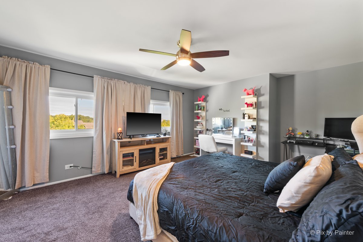 1104 Florimond Drive, Unit 1104 Elgin, IL 60123 - Photo 12 of 28 a spacious bedroom with a bed and a flat screen tv