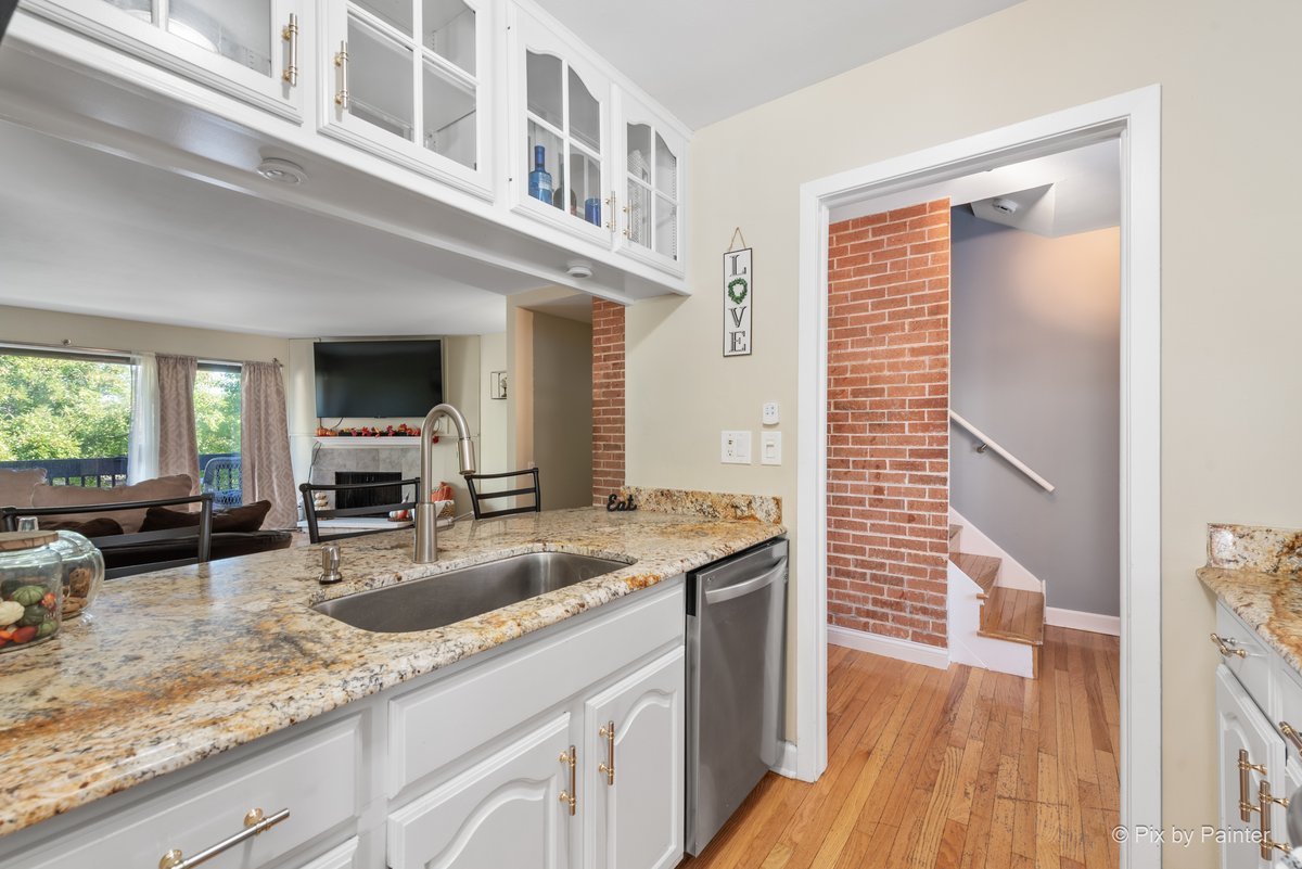 1104 Florimond Drive, Unit 1104 Elgin, IL 60123 - Photo 2 of 28 a kitchen with granite countertop a sink and a wooden floor