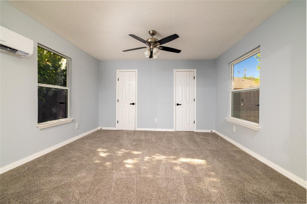 2513 Poplar Spring Road Fort Worth, TX 76123 - Photo 26 of 40 Bonus room serves also as a 4th bedroom with neutral wall paint, two windows, two paneled doors with black hardware, ceiling fan with light kit, and carpet flooring