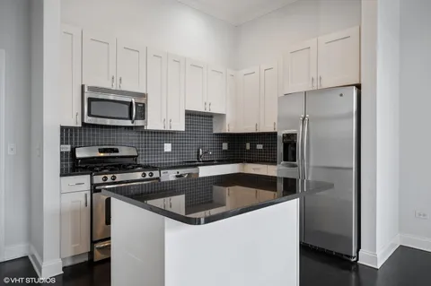 a kitchen with stainless steel appliances a stove a sink a microwave and cabinets