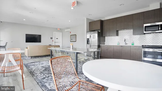 a living room with furniture a flat screen tv and kitchen view