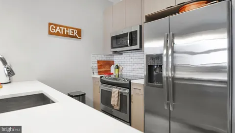 a kitchen with stainless steel appliances kitchen island a refrigerator sink and stove