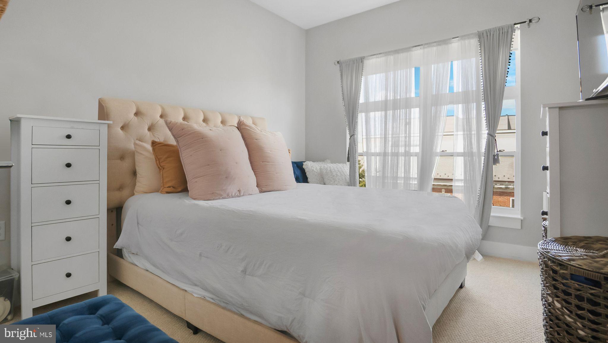 1111 Orren Street Northeast, Unit 407 Washington, DC 20002 - Photo 5 of 16 a bedroom with a bed and a window