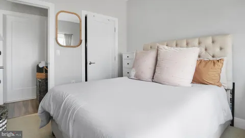 a large bed sitting in a bedroom next to a window