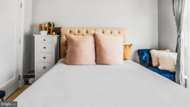 a bedroom with a bed and a refrigerator