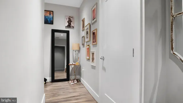 a view of a hallway with wooden floor and entryway