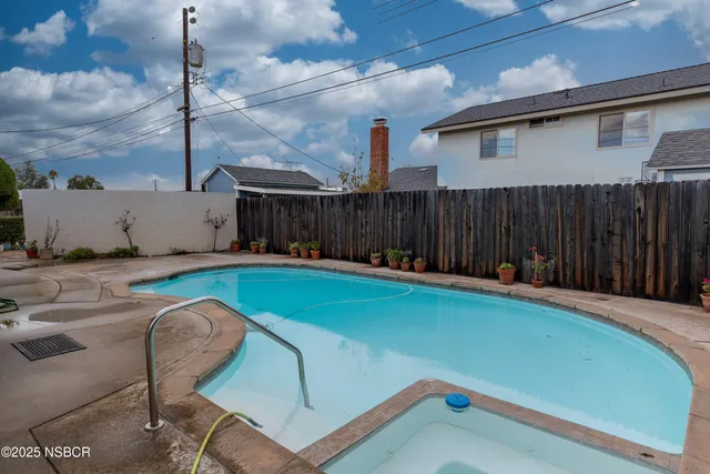 a backyard with potted plants and wooden fence