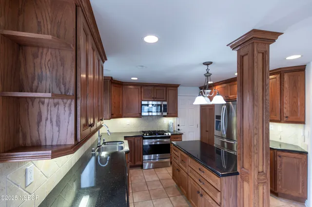a kitchen with granite countertop lots of counter top space and stainless steel appliances