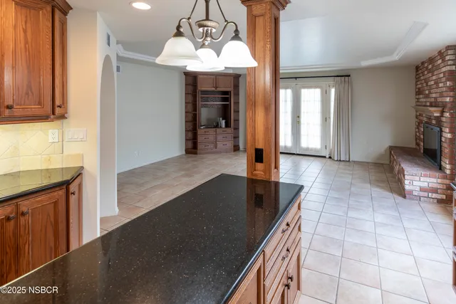 a kitchen with granite countertop a sink a stove and cabinets