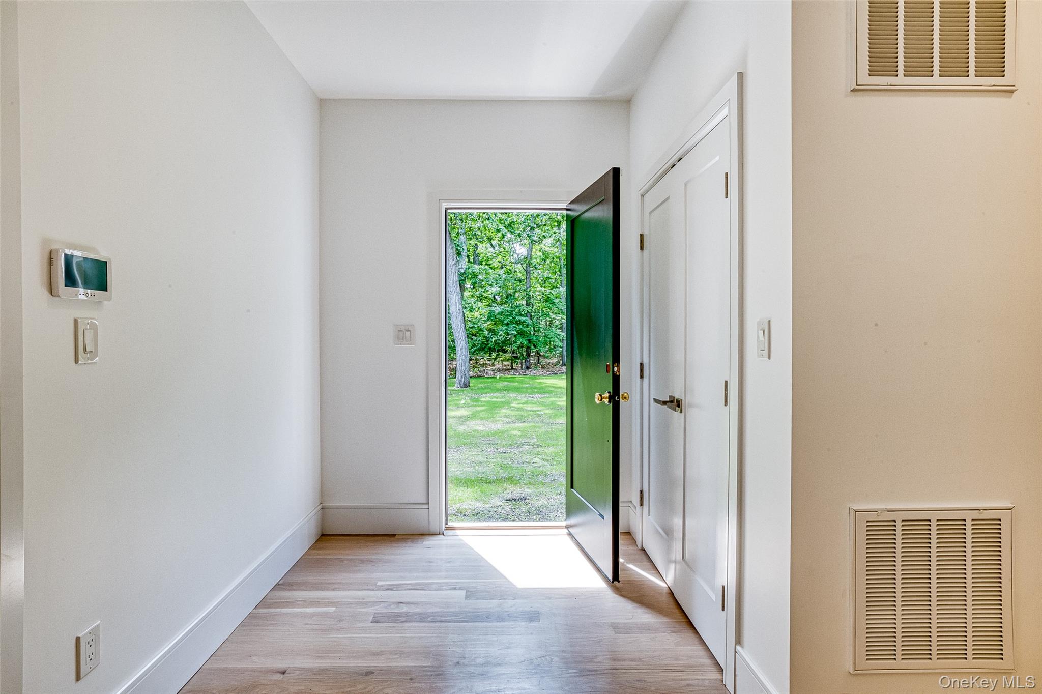 141 Old Cedar Swamp Road Jericho, NY 11753 - Photo 13 of 15 a view of hallway with a front door and wooden floor