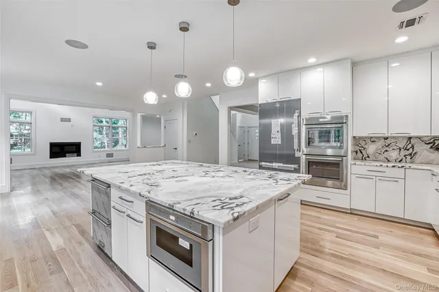 a kitchen with stainless steel appliances granite countertop a stove and a wooden floors