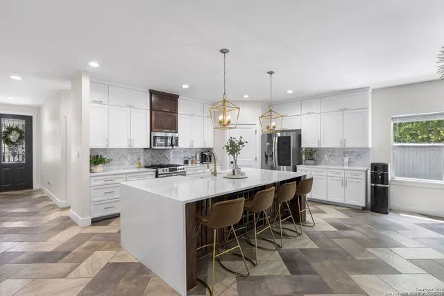 a kitchen with appliances a sink and cabinets
