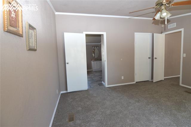 27055 Handle Road Calhan, CO 80808 - Photo 10 of 25 Another view of the master bedroom looking into the ensuite 5 piece bathroom with a walk in closet near the entry door.