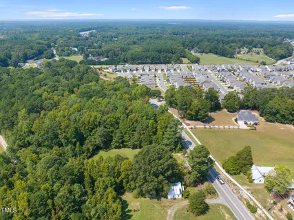 an aerial view of residential houses with outdoor space and trees